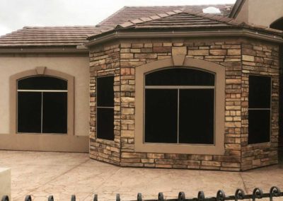 Stone-clad luxury house exterior with tiled roof.