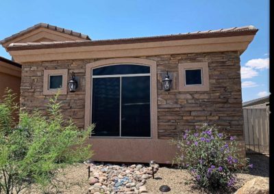 Modern house exterior with stone veneer and landscaping.