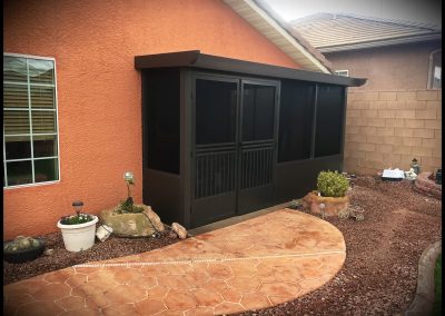 Brown house with patio and outdoor enclosure.