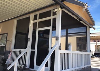 House with screened porch and white railing.