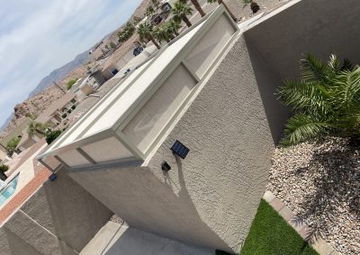 Suburban home corner with palm trees and mountain view.