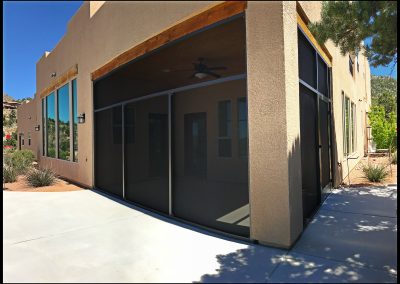 Corner view of modern stucco building with patio.