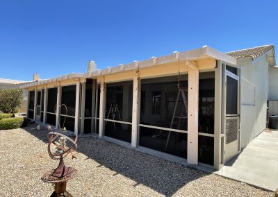 Sunlit patio with screen enclosure and decorative sundial.