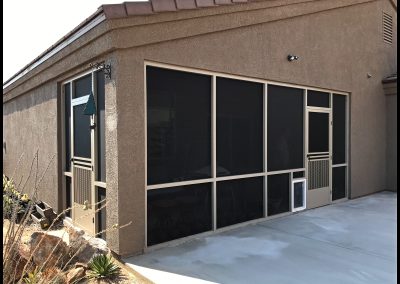 Home patio with large screen door and small pet door.