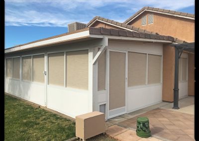 Sunroom addition on suburban home with clear skies.