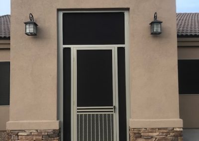 House entrance with black door and stone columns.
