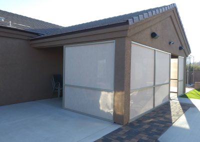 Modern house patio with large sunscreen shades.