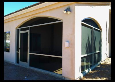 House exterior with screen door and arch window.