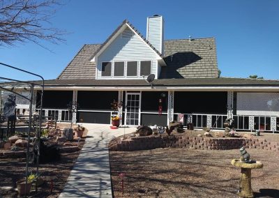 Suburban house with front porch and landscaped yard.
