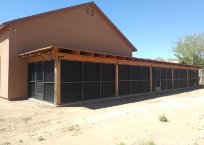 Tan building with screened enclosure in sunny desert area.