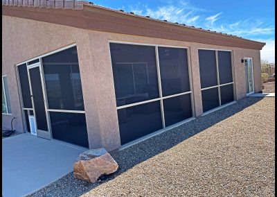 Southwestern house with large screened patio and gravel landscaping.