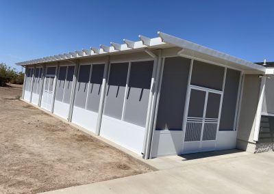 Modern building with white siding and large windows.