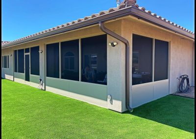 Suburban house with artificial lawn and large windows.
