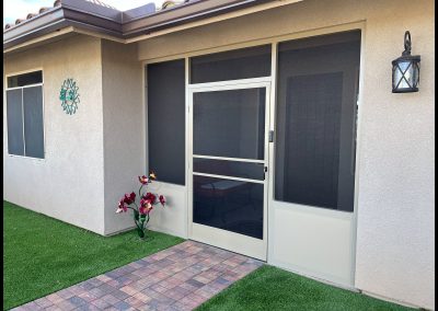 House exterior with sliding screen door and decorative light.
