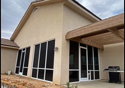 New beige house with large patio and sliding glass doors.