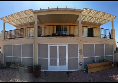 Sunlit backyard with covered patio and upper deck.