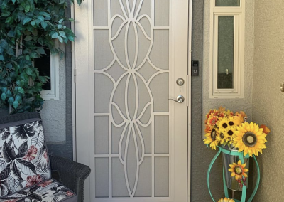 Decorative security door with floral designs and sunflowers.