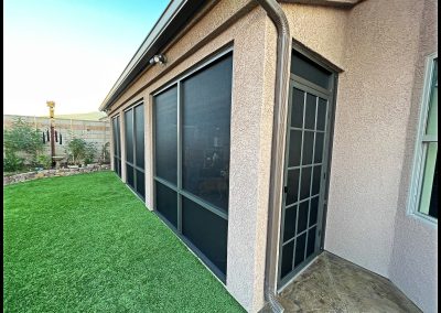 Backyard with screened patio and artificial grass.