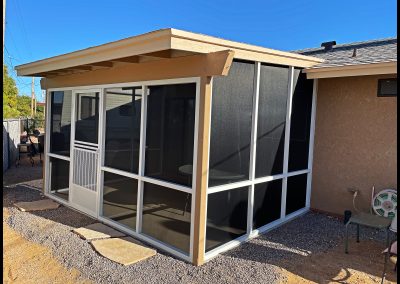 Screened patio enclosure attached to a house