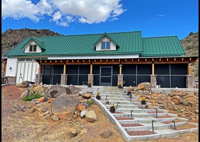 Mountain house with green roof and stone details.