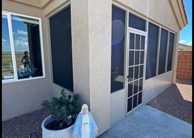 House exterior with religious statue and screened patio.