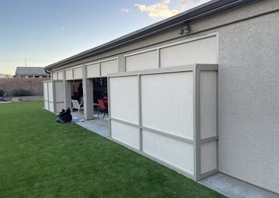 House exterior with garage door and artificial grass lawn.